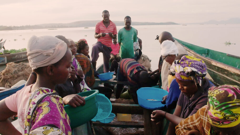 Villagers of Kogutu, Kenya, aboard a fishing boat on Lake Victoria — still from Free Money (Sundance 2023), produced by Chloe Darnaud